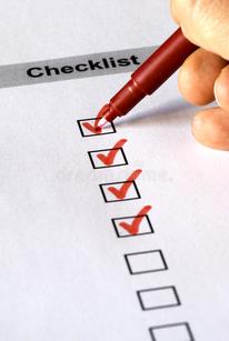 Hand placing red check marks in black boxes on a pieces of paper titled checklist.