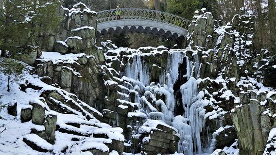 Scenery with a bridge and icy waterfall