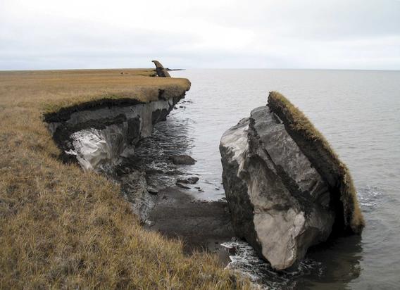 Piece of land breaking off into body of water on coastline.