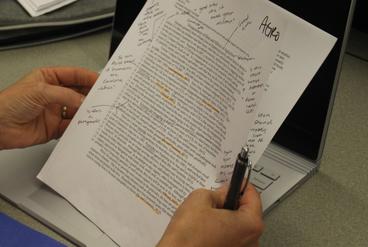 Hands holding a student paper with written feedback